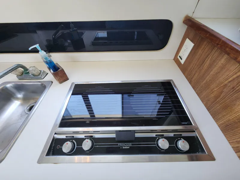 Slide: The Image of 1988 Chris-Craft 315 Commander kitchen with stove, sink, and countertop. - 28