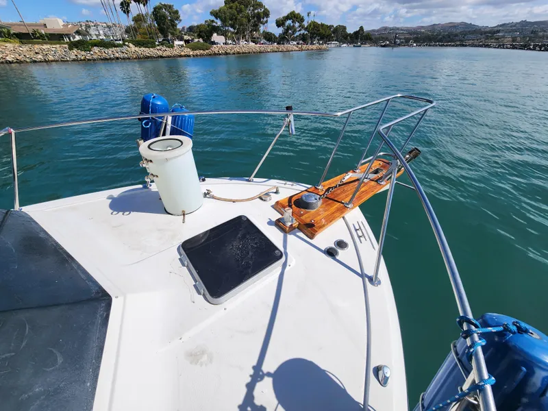 Slide: The Image of 1988 Chris-Craft 315 Commander boat on calm water, featuring deck and railing. - 3