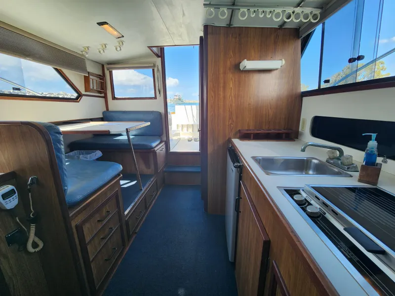 Slide: The Image of Interior of 1988 Chris-Craft 315 Commander boat with kitchen and dining area. - 32