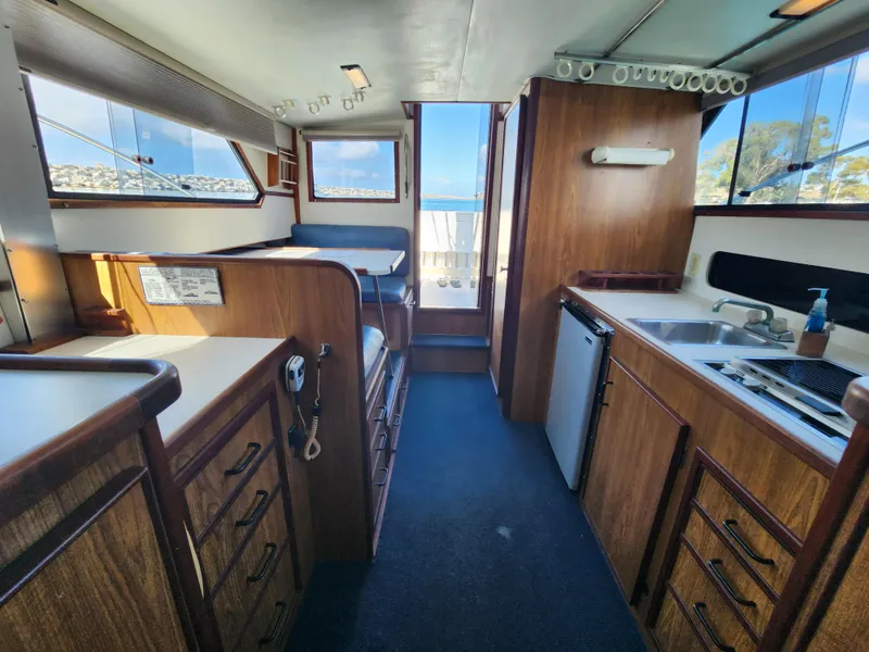 Slide: The Image of Interior of 1988 Chris-Craft 315 Commander boat with wood cabinetry and compact kitchen. - 33
