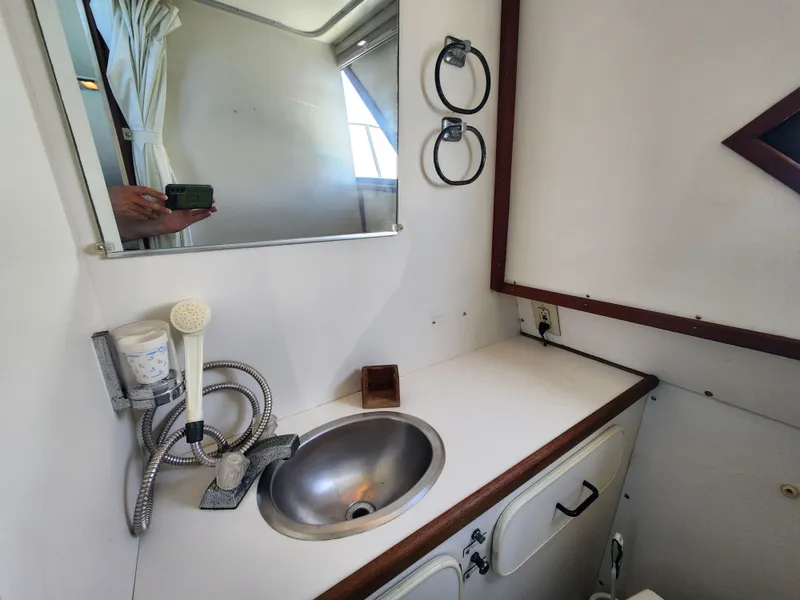 Slide: The Image of 1988 Chris-Craft 315 Commander bathroom with sink, mirror, and storage. - 40