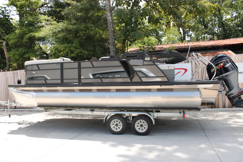 The Image of 2025 Starcraft EXS 3 Q DH pontoon boat on trailer, parked outdoors. - 1