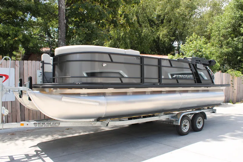 Slide: The Image of 2025 Starcraft EXS 3 Q DH pontoon boat on trailer, parked outdoors. - 3