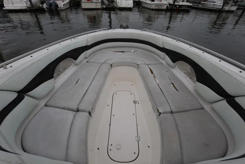 Slide: The Image of 2002 Chaparral 280 SSi boat interior with worn seating at a marina. - 11
