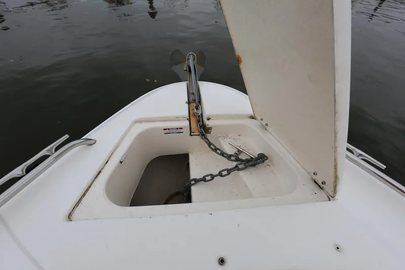 Slide: The Image of Open anchor compartment on 2002 Chaparral 280 SSi boat, showing chain and water background. - 13