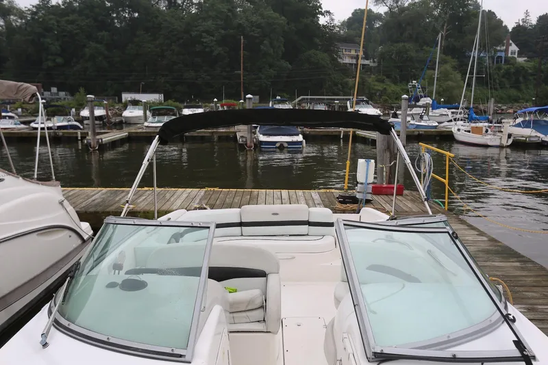 Slide: The Image of 2002 Chaparral 280 SSi boat docked at a marina with surrounding boats. - 17