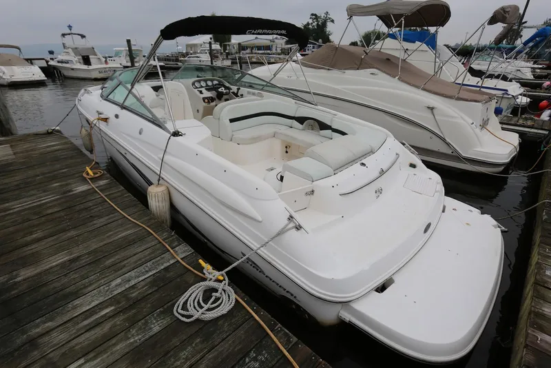 Slide: The Image of 2002 Chaparral 280 SSi boat docked at marina, featuring spacious seating and sleek design. - 2