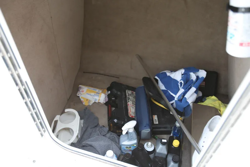 Slide: The Image of Storage compartment of a 2002 Chaparral 280 SSi boat with various items and supplies. - 27
