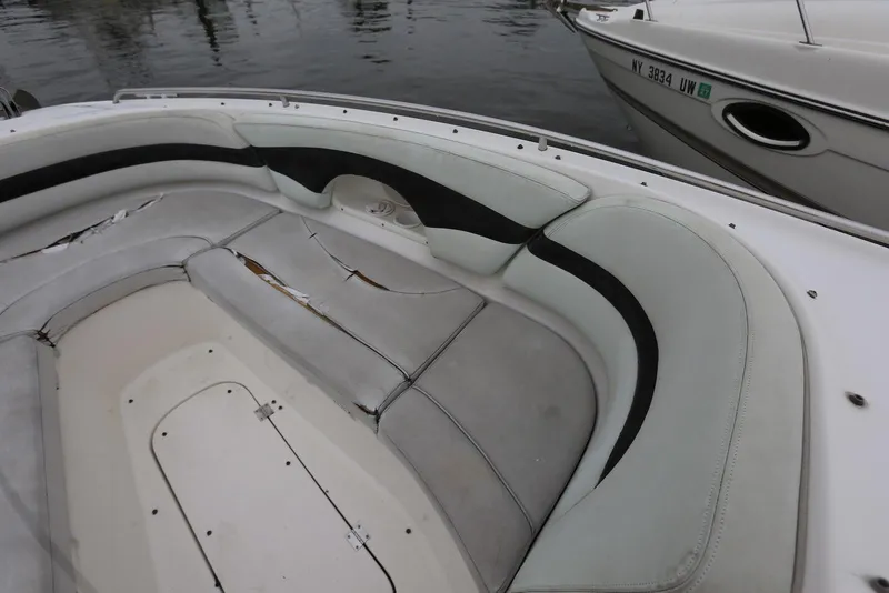 Slide: The Image of 2002 Chaparral 280 SSi boat interior with worn seating, docked beside another vessel. - 29