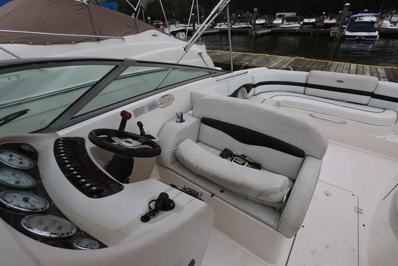 Slide: The Image of 2002 Chaparral 280 SSi boat interior with steering wheel and seating at a marina. - 32