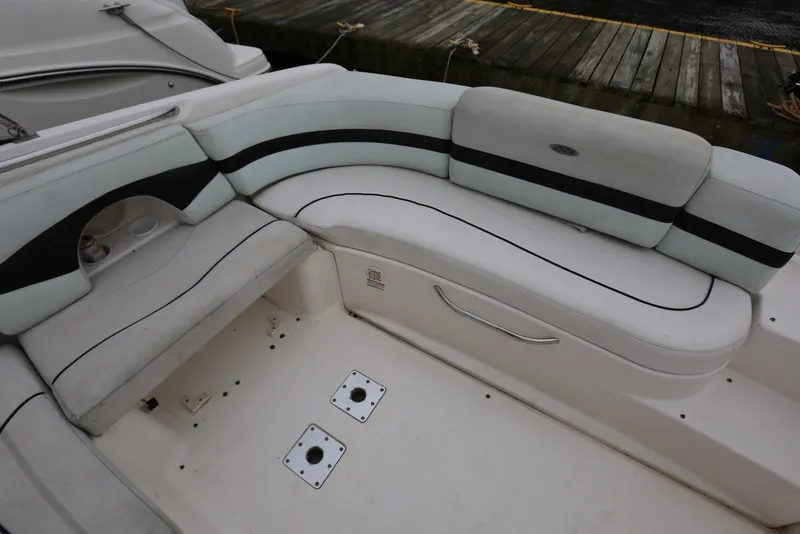 Slide: The Image of 2002 Chaparral 280 SSi boat interior with white and black seating near dock. - 36