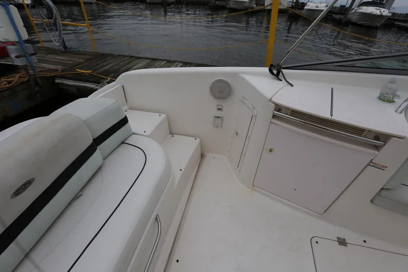 Slide: The Image of 2002 Chaparral 280 SSi boat interior with seating and storage, docked by the water. - 37