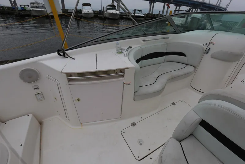 Slide: The Image of 2002 Chaparral 280 SSi boat interior with seating and storage, docked by the water. - 38