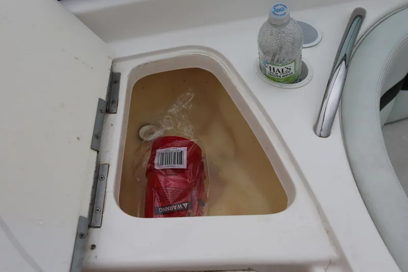 Slide: The Image of Storage compartment on 2002 Chaparral 280 SSi boat with bottle and packaged item. - 43