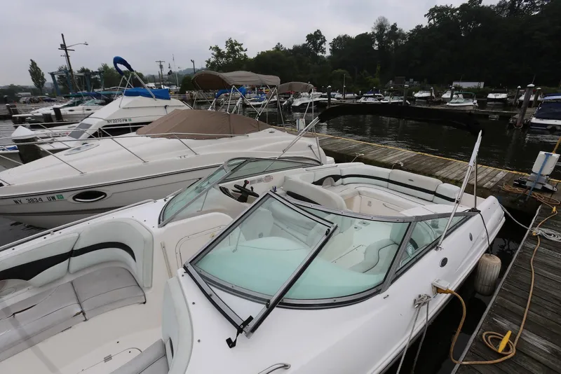 Slide: The Image of 2002 Chaparral 280 SSi boat docked at a marina, surrounded by other vessels. - 7