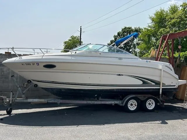 The Image of 2001 Sea Ray 245 Weekender boat on trailer, parked outdoors. - 0