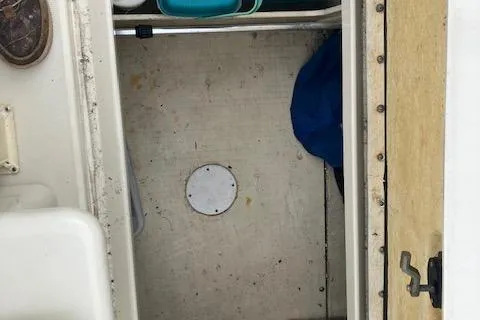 Slide: The Image of 2001 Sea Ray 245 Weekender cabin interior with storage space and visible hatch. - 6