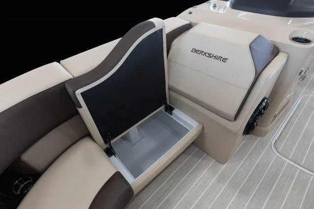 Slide: The Image of 2023 Berkshire 23RFX STS boat interior with open storage compartment, beige and brown seating. - 10