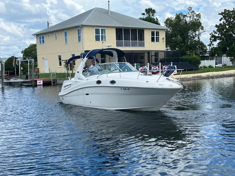 Slide: The Image of 2005 Sea Ray Sundancer 260 on calm water near a house. - 7