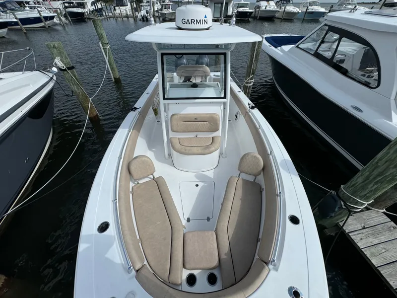 Slide: The Image of 2020 Sportsman Open 252 Center Console boat docked, featuring spacious seating and Garmin equipment. - 23