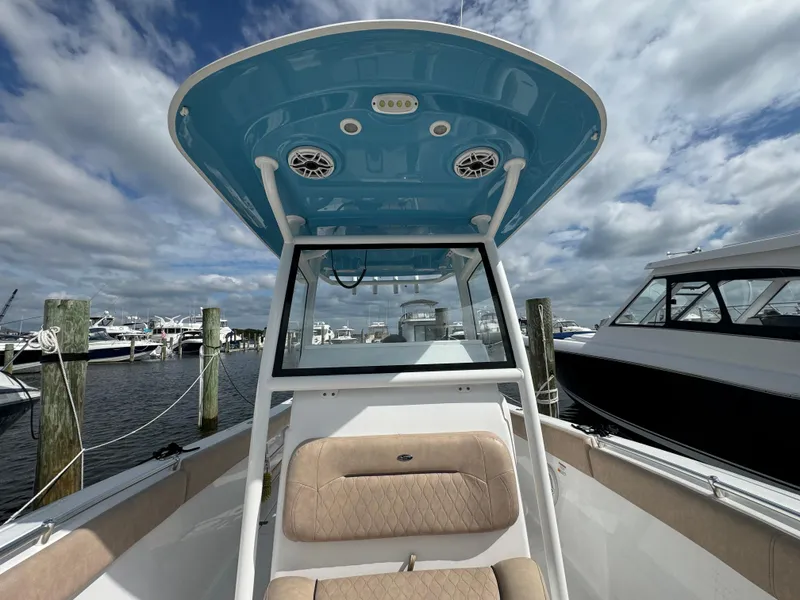 Slide: The Image of 2020 Sportsman Open 252 Center Console boat at marina, blue T-top, cloudy sky. - 25