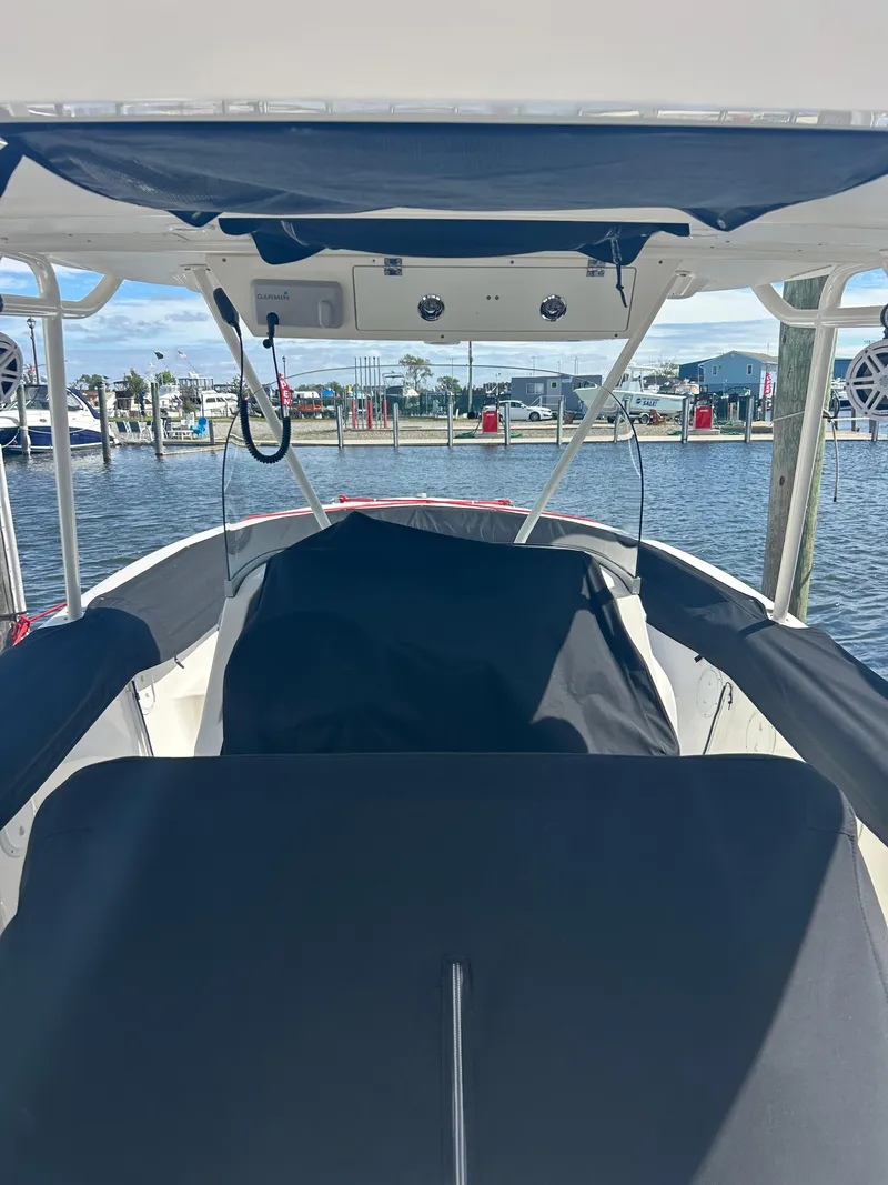 Slide: The Image of 2016 Pursuit S 280 Sport boat interior at marina, covered seating, clear sky. - 13