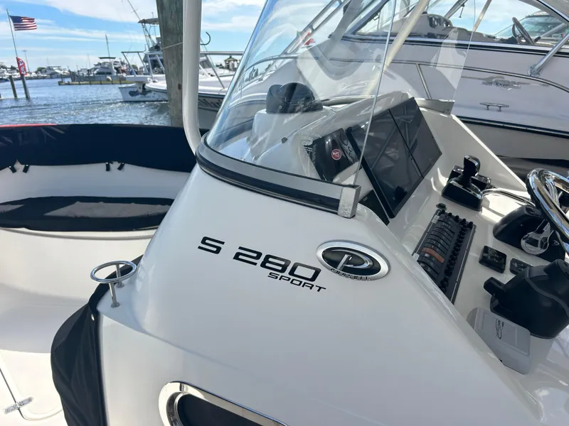 Slide: The Image of 2016 Pursuit S 280 Sport boat dashboard with marina background. - 23