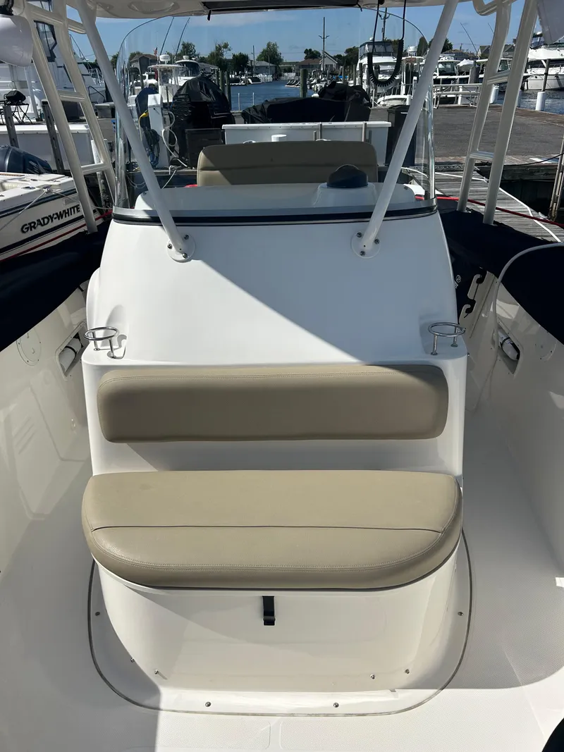 Slide: The Image of 2016 Pursuit S 280 Sport boat interior with beige seating, docked at marina. - 25