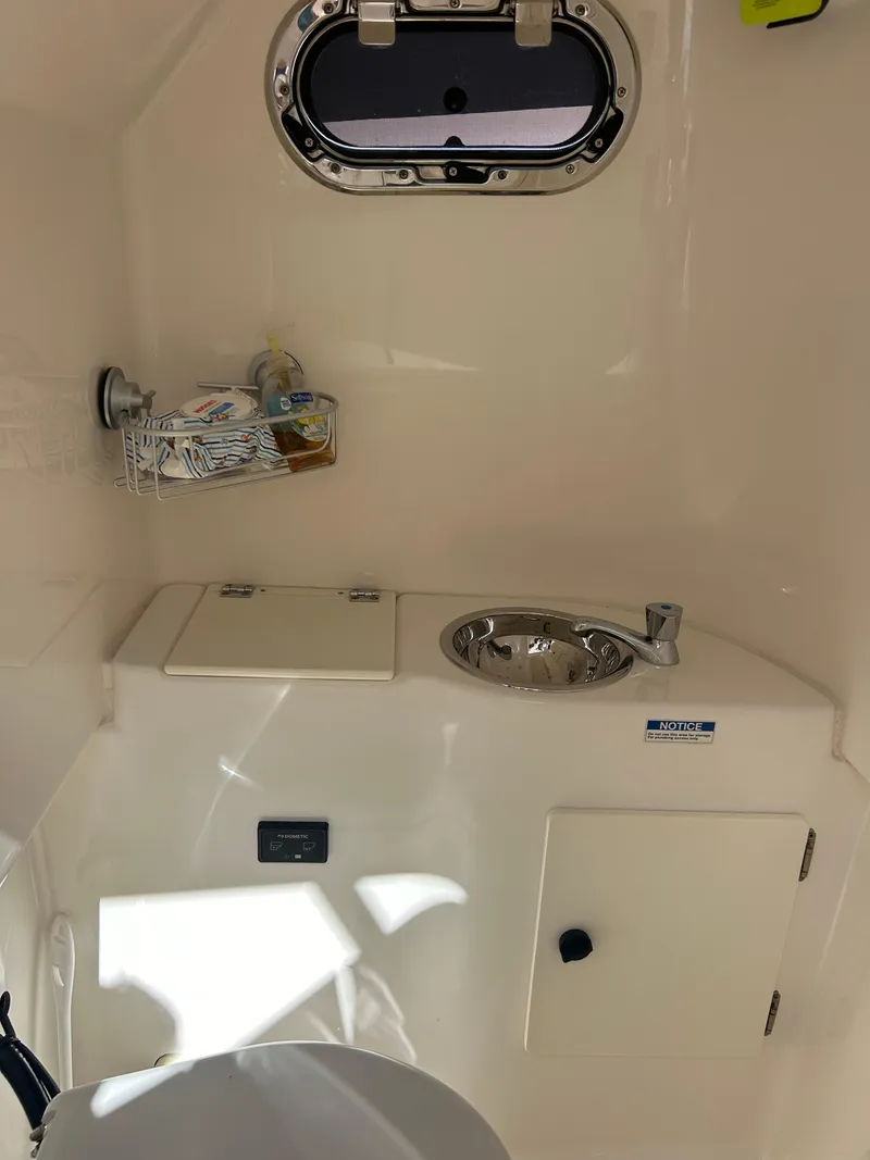 Slide: The Image of 2016 Pursuit S 280 Sport boat interior with sink and storage. - 26