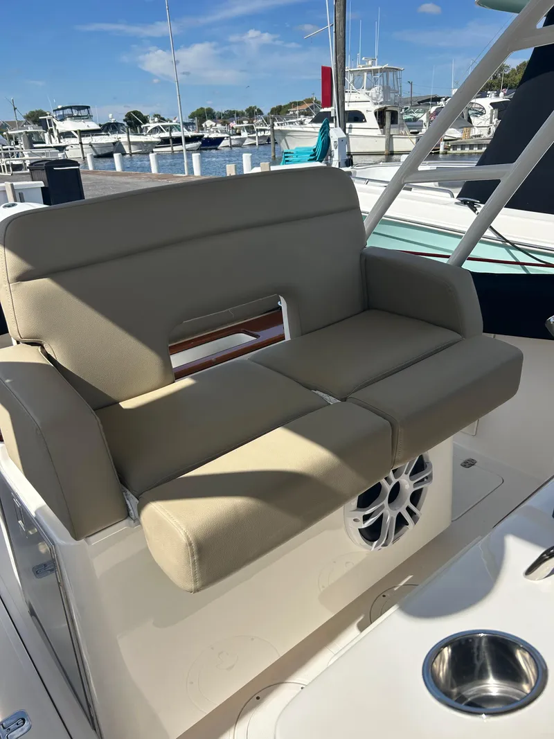 Slide: The Image of 2016 Pursuit S 280 Sport boat seating with speaker, docked at marina. - 29