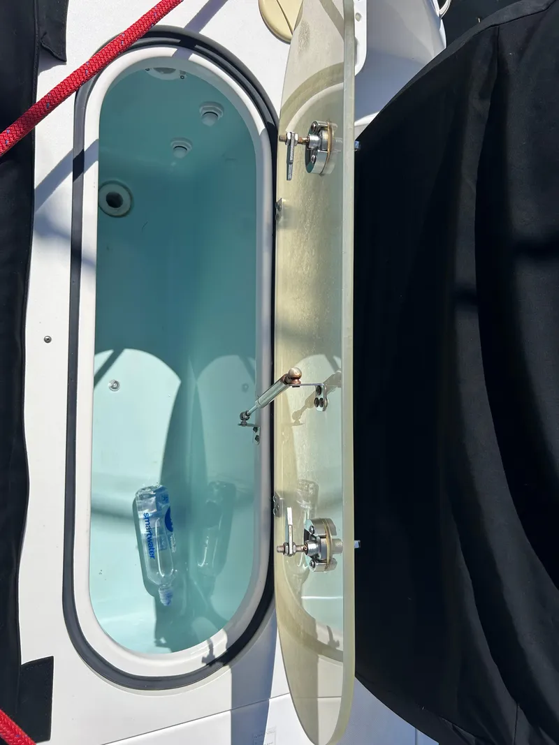 Slide: The Image of Open storage compartment on 2016 Pursuit S 280 Sport boat with water bottle inside. - 37