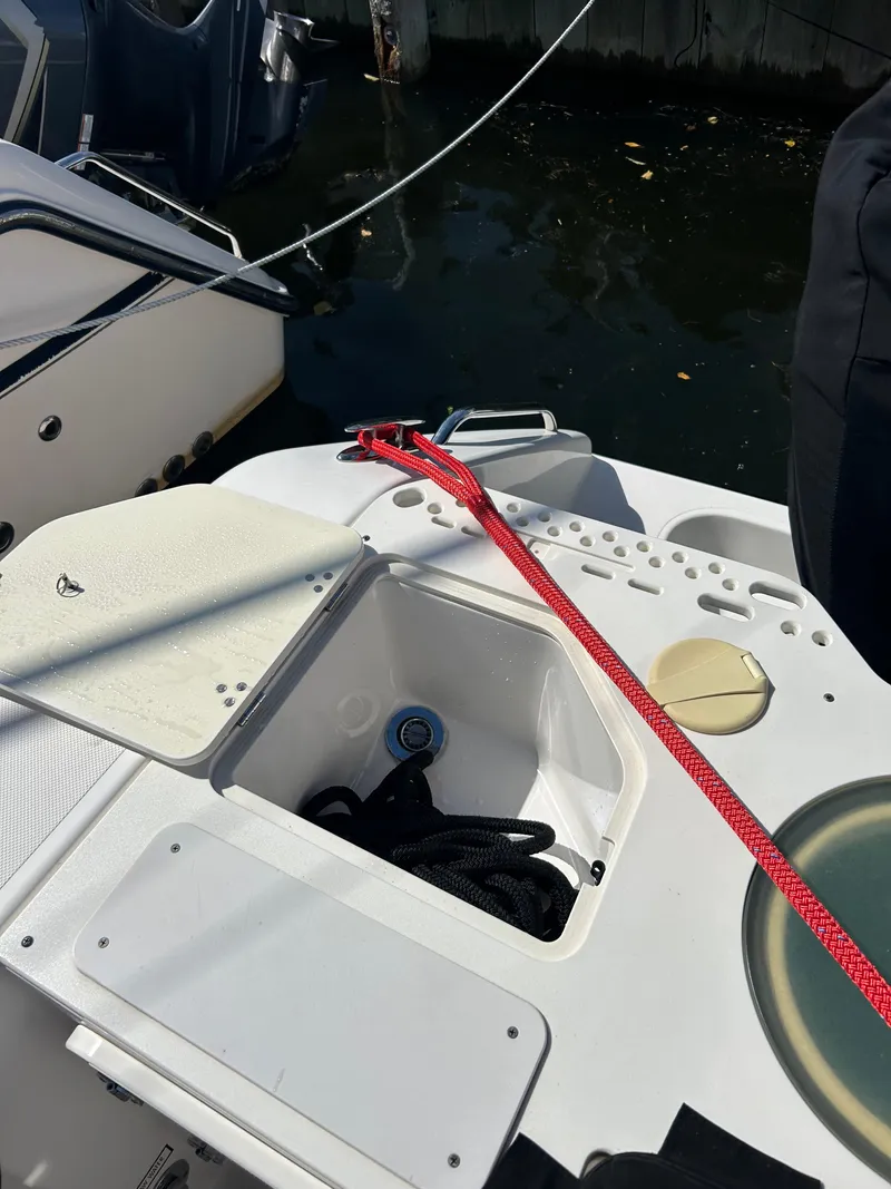 Slide: The Image of 2016 Pursuit S 280 Sport boat deck with storage compartment and red rope. - 38