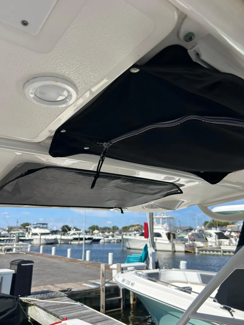 Slide: The Image of 2016 Pursuit S 280 Sport boat docked at marina with open storage compartment. - 43