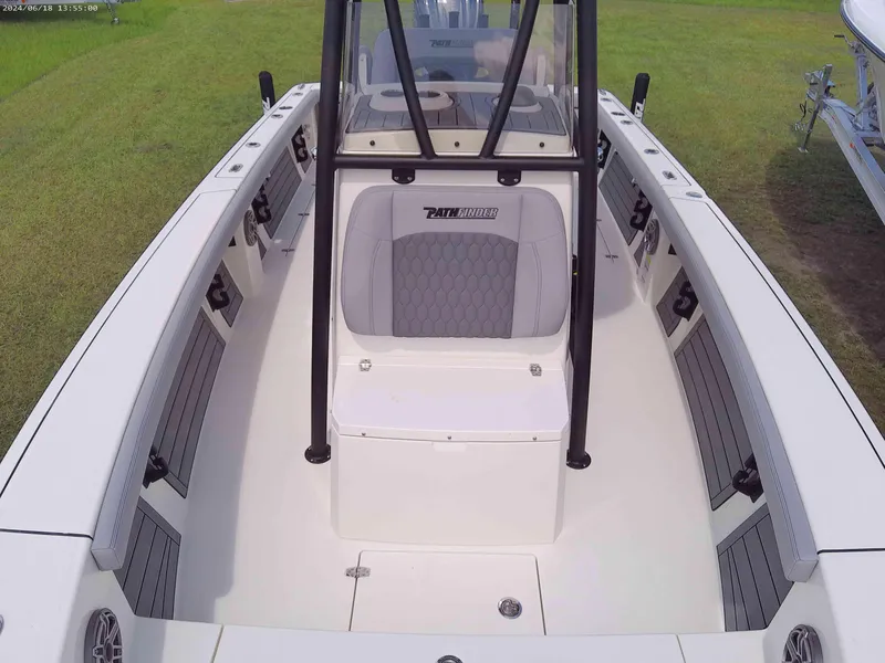 Slide: The Image of 2025 Pathfinder 2400 Open boat interior with seating and console, parked on grass. - 7