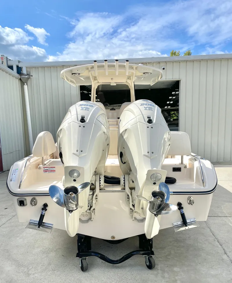 Slide: The Image of 2025 Grady-White 281 Coastal Explorer boat with dual outboard engines, docked outdoors. - 6