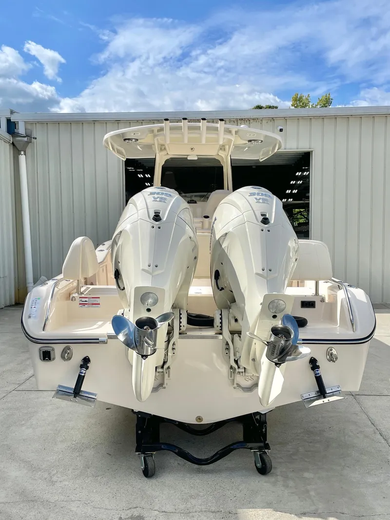 Slide: The Image of 2025 Grady-White 281 Coastal Explorer boat with dual engines, docked outdoors. - 7
