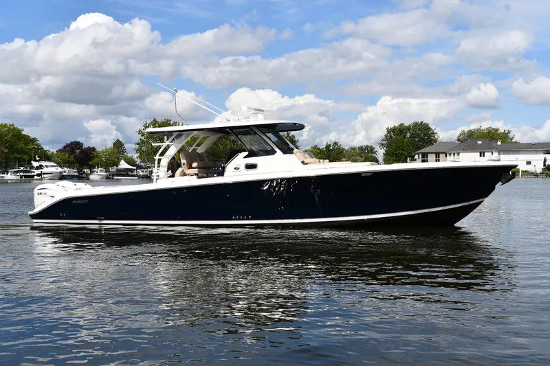 The Image of 2019 Pursuit S 408 Sport boat on calm water under a partly cloudy sky. - 0
