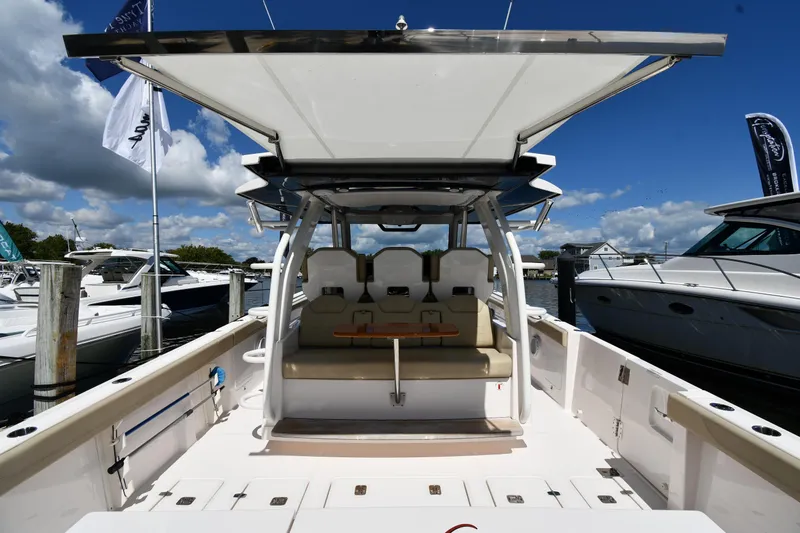 Slide: The Image of 2019 Pursuit S 408 Sport boat interior with seating and canopy, docked at marina. - 10