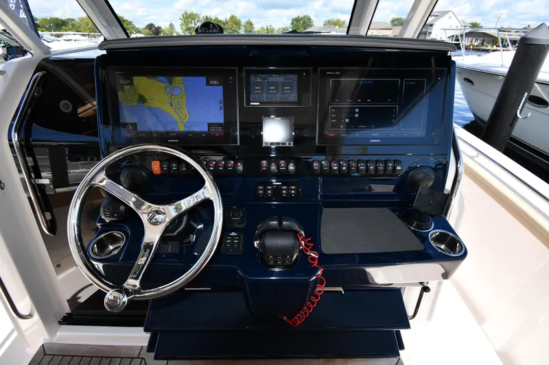 Slide: The Image of 2019 Pursuit S 408 Sport boat dashboard with navigation screens and steering wheel. - 14