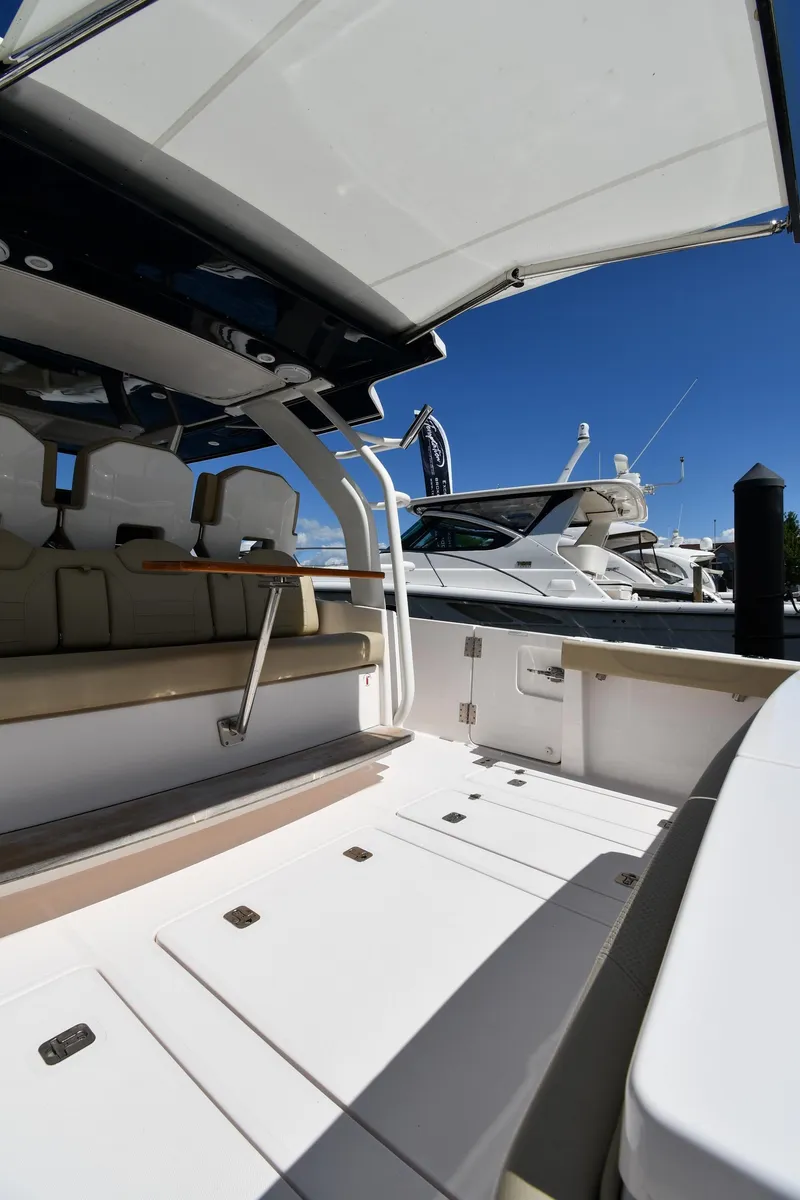 Slide: The Image of 2019 Pursuit S 408 Sport boat interior with seating and open deck under clear blue sky. - 21