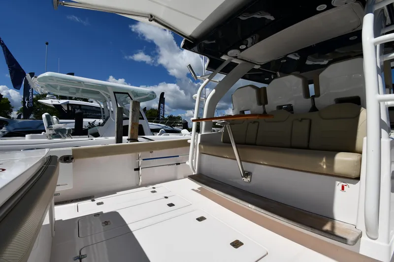 Slide: The Image of 2019 Pursuit S 408 Sport boat interior with seating and open deck under blue sky. - 22