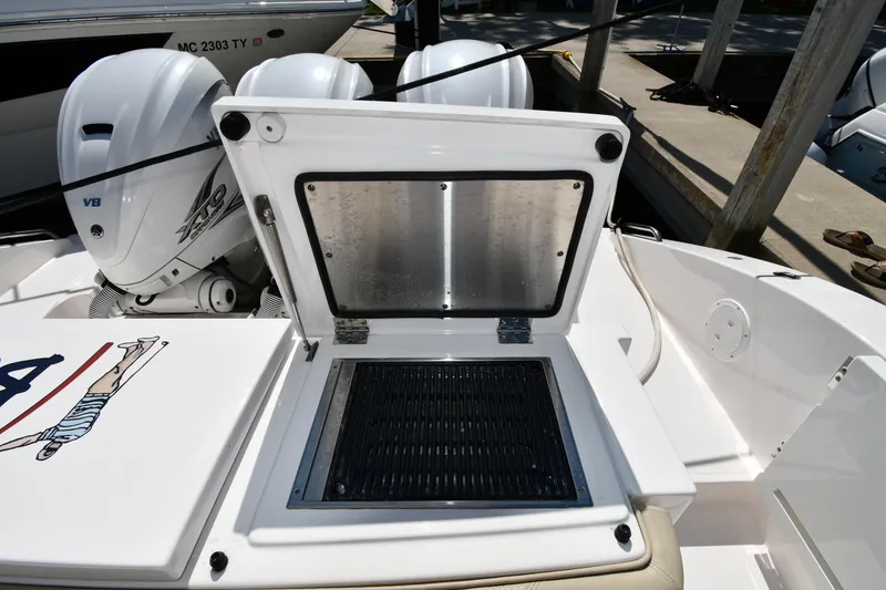 Slide: The Image of 2019 Pursuit S 408 Sport boat with open storage compartment and dual outboard engines. - 27