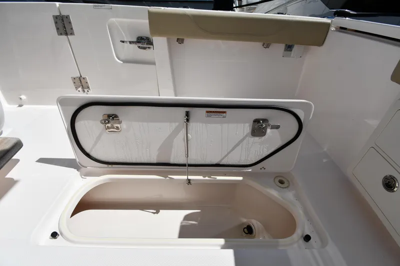 Slide: The Image of 2019 Pursuit S 408 Sport boat storage compartment open, showcasing interior space. - 32