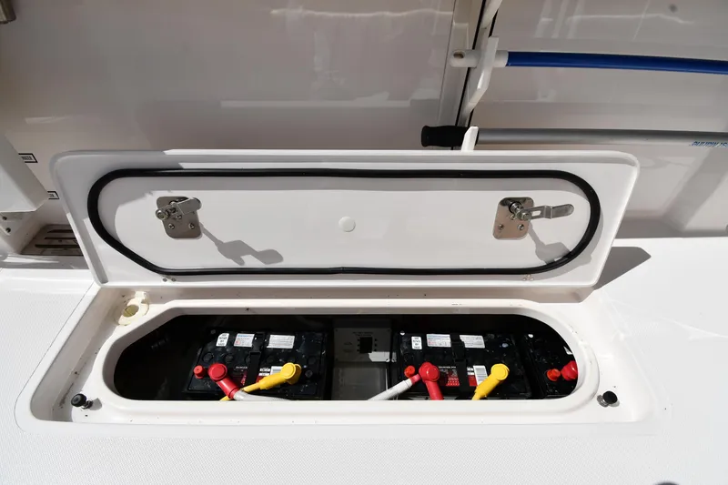 Slide: The Image of Battery compartment of 2019 Pursuit S 408 Sport boat, featuring secure latches and wiring. - 33