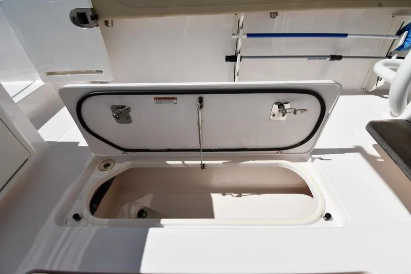 Slide: The Image of 2019 Pursuit S 408 Sport boat storage compartment open, showcasing interior space. - 34