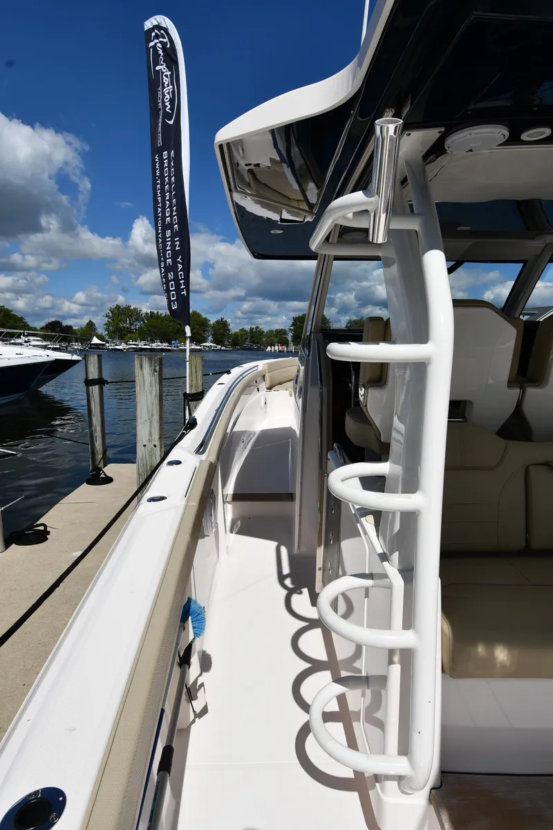 Slide: The Image of 2019 Pursuit S 408 Sport boat docked, showcasing sleek design and ladder. - 38