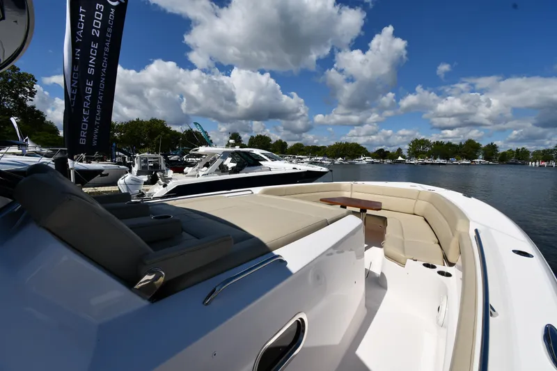 Slide: The Image of 2019 Pursuit S 408 Sport boat docked under a blue sky with clouds. - 40