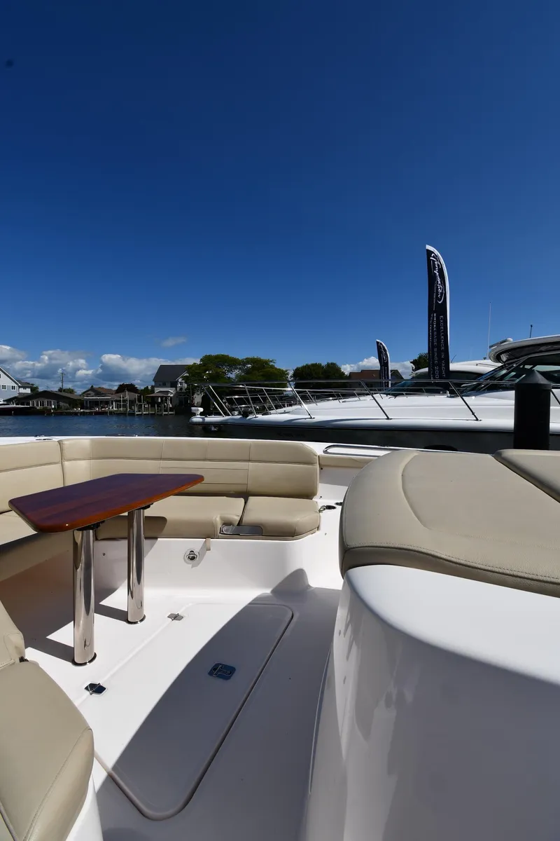Slide: The Image of 2019 Pursuit S 408 Sport boat with beige seating and wooden table under clear blue sky. - 42