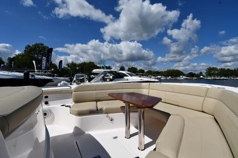 Slide: The Image of 2019 Pursuit S 408 Sport boat with beige seating and table under blue sky. - 43