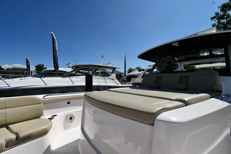 Slide: The Image of 2019 Pursuit S 408 Sport boat with beige seating, displayed outdoors under clear blue sky. - 47